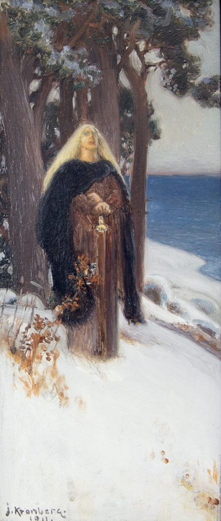 Ung kvinna, helfigur, med lång rödbrun klänning och lång svart kappa stående i dagsljus i ett snötäckt landskap med tallar och sjö.