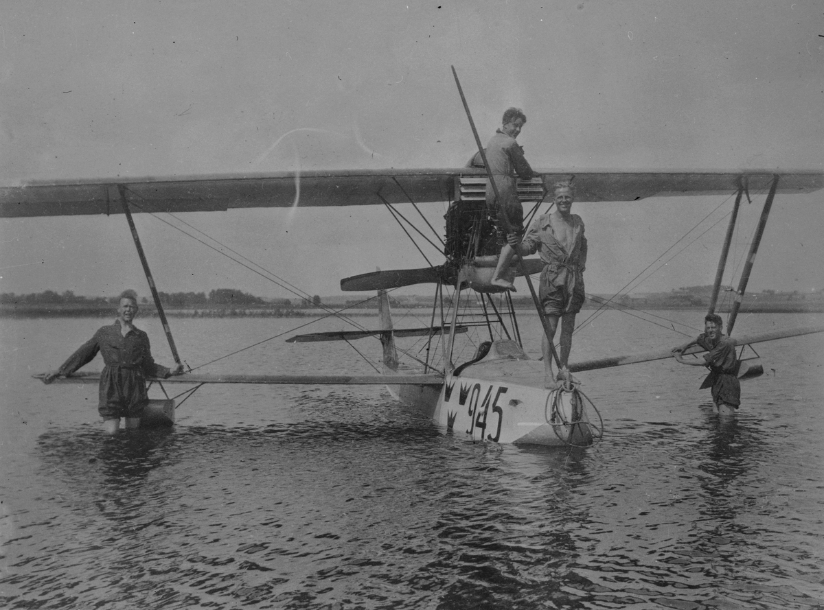 Flygplan Macchi M.7 märkt nummer 945 på sjön Roxen vid Bergs slussar. Fyra män vid flygplanet.
