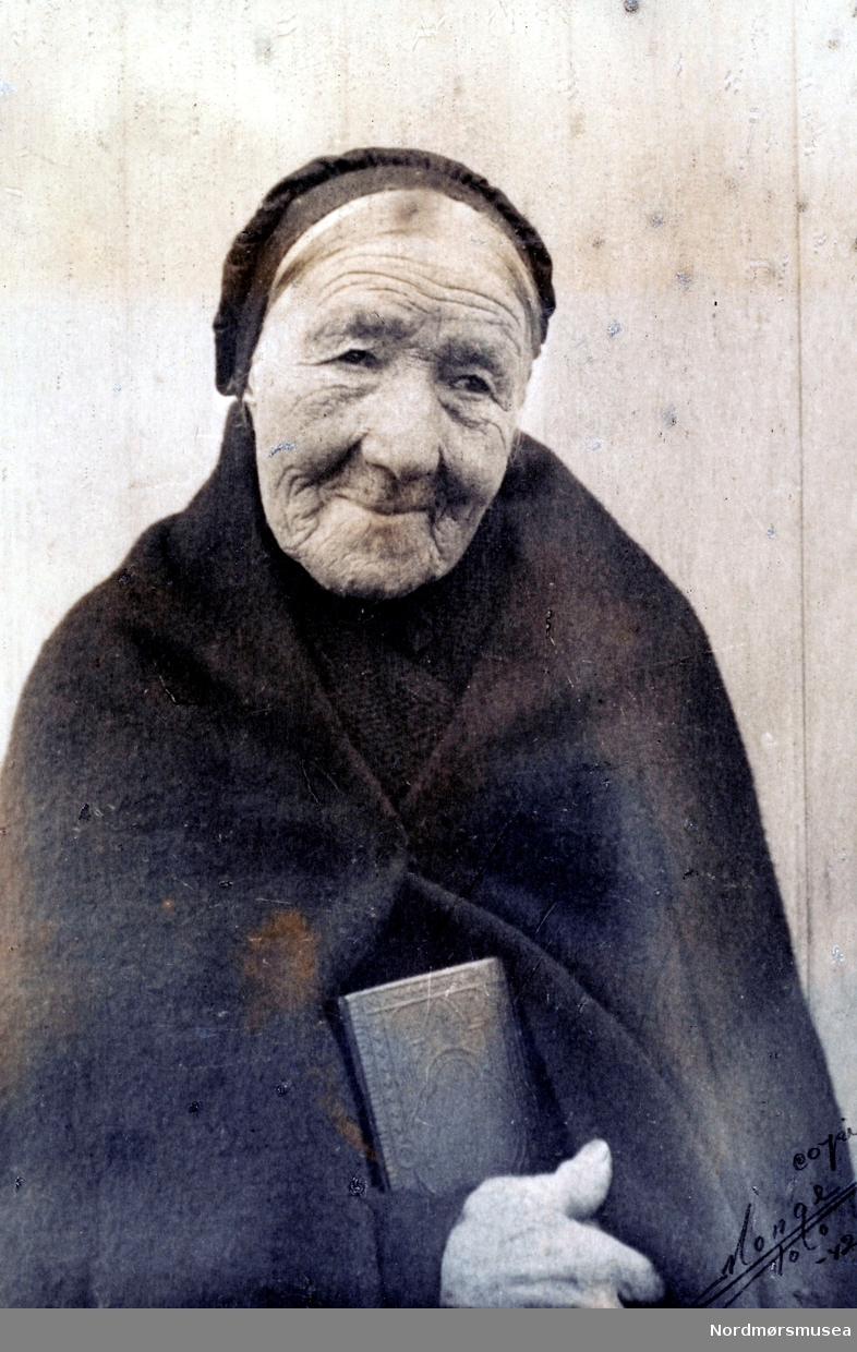 Portrett av en gammel kvinne fra Todalen i Surnadal kommune. Legg merke til den gamle kirkedrakten. Datering er usikker, men bildet er reprodusert av Monge i 1942. Fra Nordmøre museums fotosamlinger.
