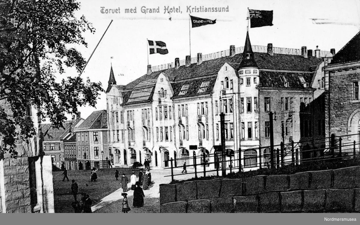 Prospektkort, Postkort med teksten: Torvet med Grand Hotell, Kristianssund.
Litt av Norges bank til høyre.  Den var ny i 1908-09.
(Frå Nordmøre Museum si fotosamling)