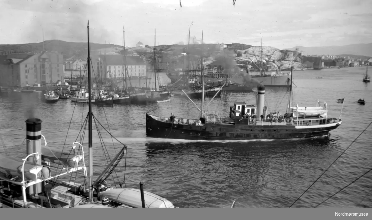 Foto fra havnebassenget som er full av fartøy av forskjellig slag; rutebåter, fiskebåter og transportskip med mere. Fra Nordmøre Museum sin fotosamling.
