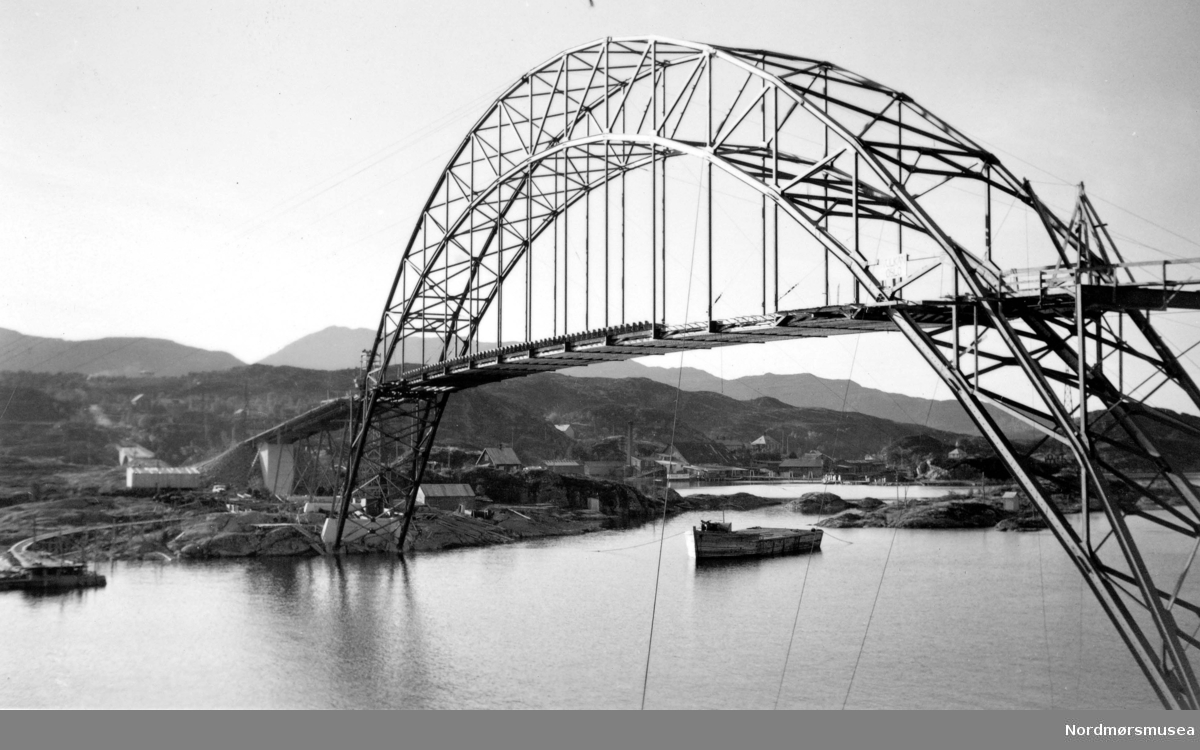 Omsundet bru under konstruksjon. Omsund bru krysser Omsundet mellom øyene Frei og Nordlandet i Kristiansund kommune. Broen er 281 meter lang og ble tatt i bruk april 1940, men fikk aldri en offisiell åpning på grunn av utbruddet av 2. verdenskrig. Broen ble prøvd bombet av tyskerne, men holdt, men 15 år gamle Ingolf Vatten som syklet over broen da tyskerne bombet broen ble drept. Broen var også viktig da Kristiansund ble evakuert. Broen ble åpnet offisielt 24. april 2005, 65 år etter at den ble tatt i bruk. Per i dag 2008 er denne broen bare åpen for fotgjengere og en ny bro ved siden av den gamle er blitt bygd. Denne er en del av riksvei 70. Fotograf er usikker, men sannsynligvis Georg Sverdrup. Fra Nordmøre Museums fotosamlinger. Kilde: http://no.wikipedia.org/wiki/Omsundbrua
