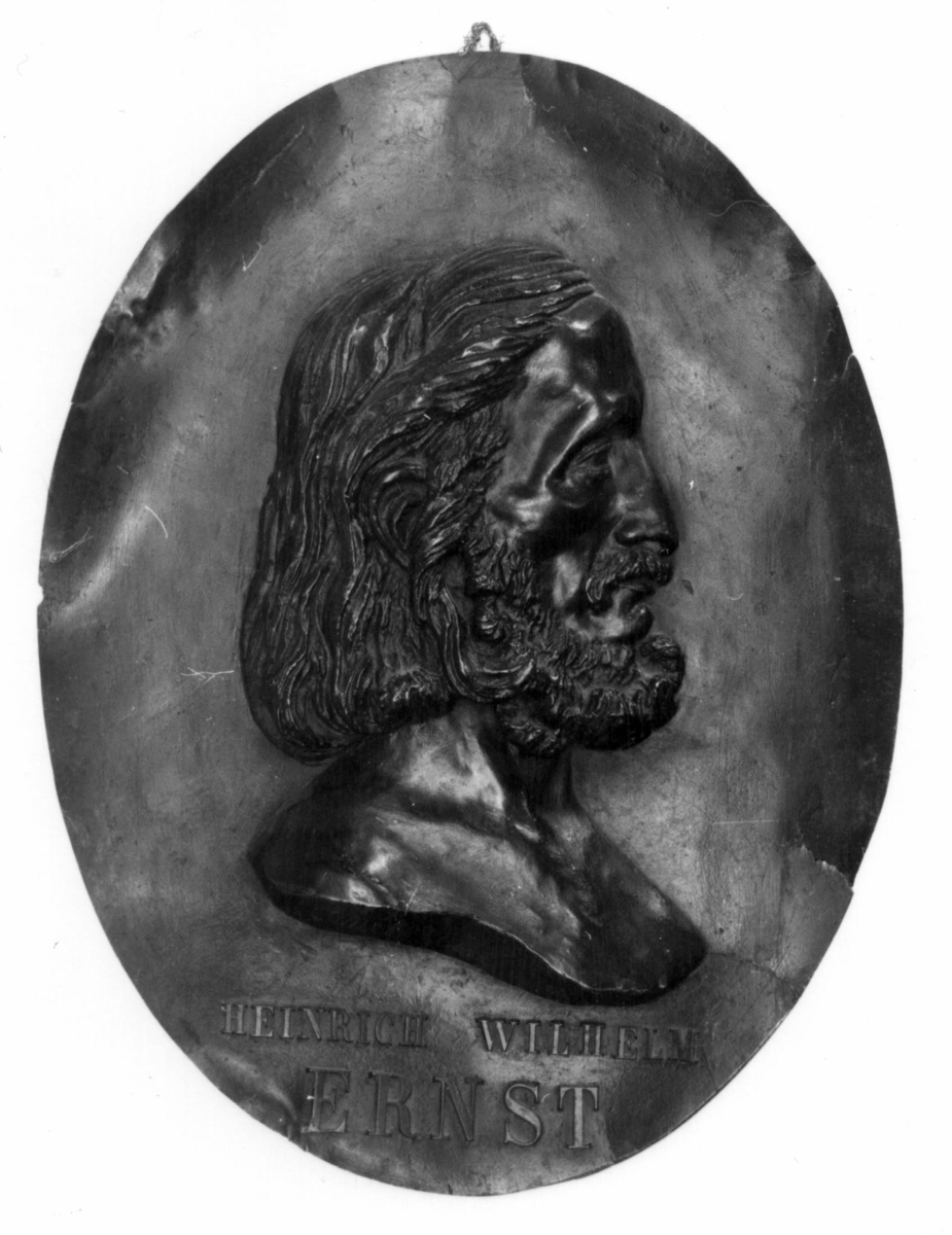 Relieff av Ernst's hode og ene skulder på oval plate.