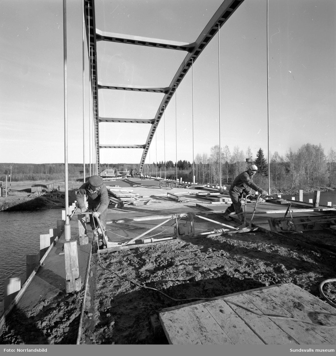 Vägmaskiner och byggare vid färdigställandet av bron över till Skeppsholmen vid Lövudden.