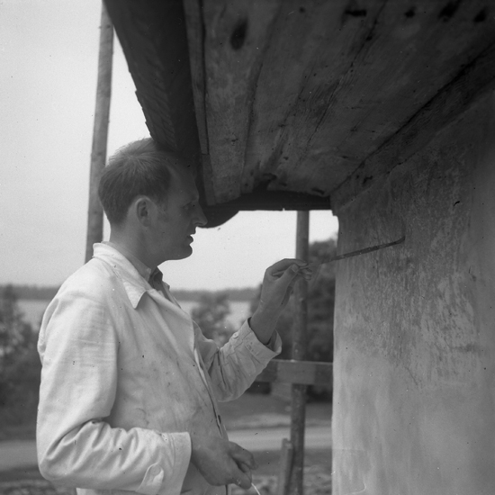 Sjösås gamla kyrka. 
Konservator Wahlgren fyller i en gammal fasaddekoration, 1943.