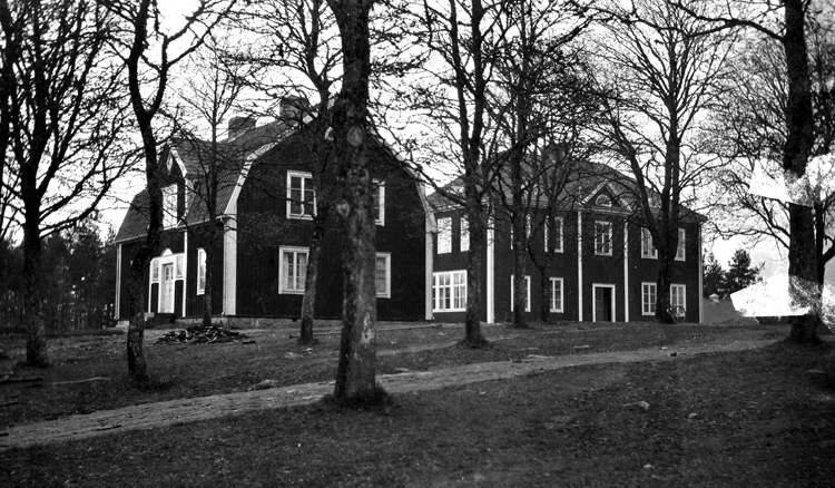 Foto på två hus, varav det bortre är skolan och det närmast är lärarbostaden.