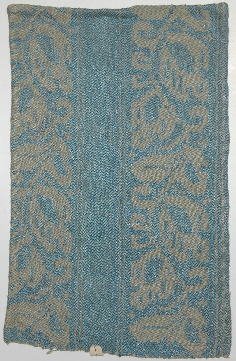 Tidigare katalogisering enl uppgift av Elisabeth Thorman kompletterad 1958 av Elisabeth Stawenow:

Möbeltyger, damast, 13 st, prover i olika färger

k) 16 x 25 cm. Varp av ljusgrått merc. bomullsgarn. Väft av ljusblått lingarn. Nr 50 f.