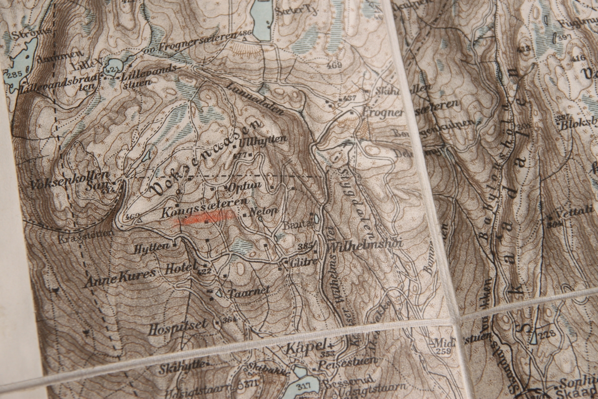 Kart over Nordmarka i Oslo. Kartet kan brettes sammen og inn i et grønt omslag av papp.