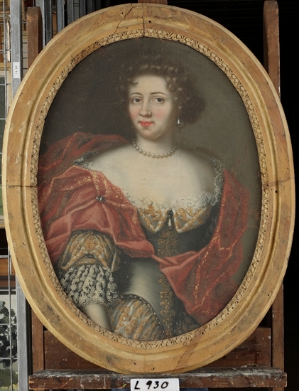 Oljemålning på duk. 
Kvinna i guld- och silverdekorerad kläning med röd mantel.
Porträtt föreställande en kvinnlig medlem av familjen Eldstierna, som på 1600-talet ägde Aneboda säteri.
Knäbild, halvprofil.
Mått: utan ram 805 x 590 mm.

Inskrivet i huvudbok 1870.

Eldstierna - friherrlig ätt. Porträttet kan möjl. föreställa Katarina Kyle (1642-1699) gift med landshövdingen i Östergötland friherre Lars Larsson Eldstierna (1623-1701).
Montering/Ram: Oval träram med palmettbård (spår av gul färg).
