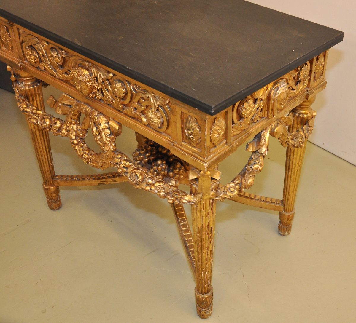 Bordet er av forgylt tre med toppplate av stein. Bordet er riklig utskåret. Bordet er i fransk ny-klassisisme, nærmere bestemt Louis XVI.