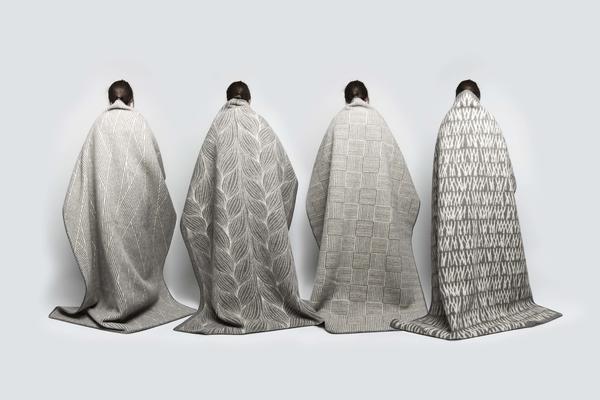 Kristine Five Melværs fire Naturpledd, designet for Røros Tweed. De fire pleddene, med ulike mønstre, henger over fire rygger