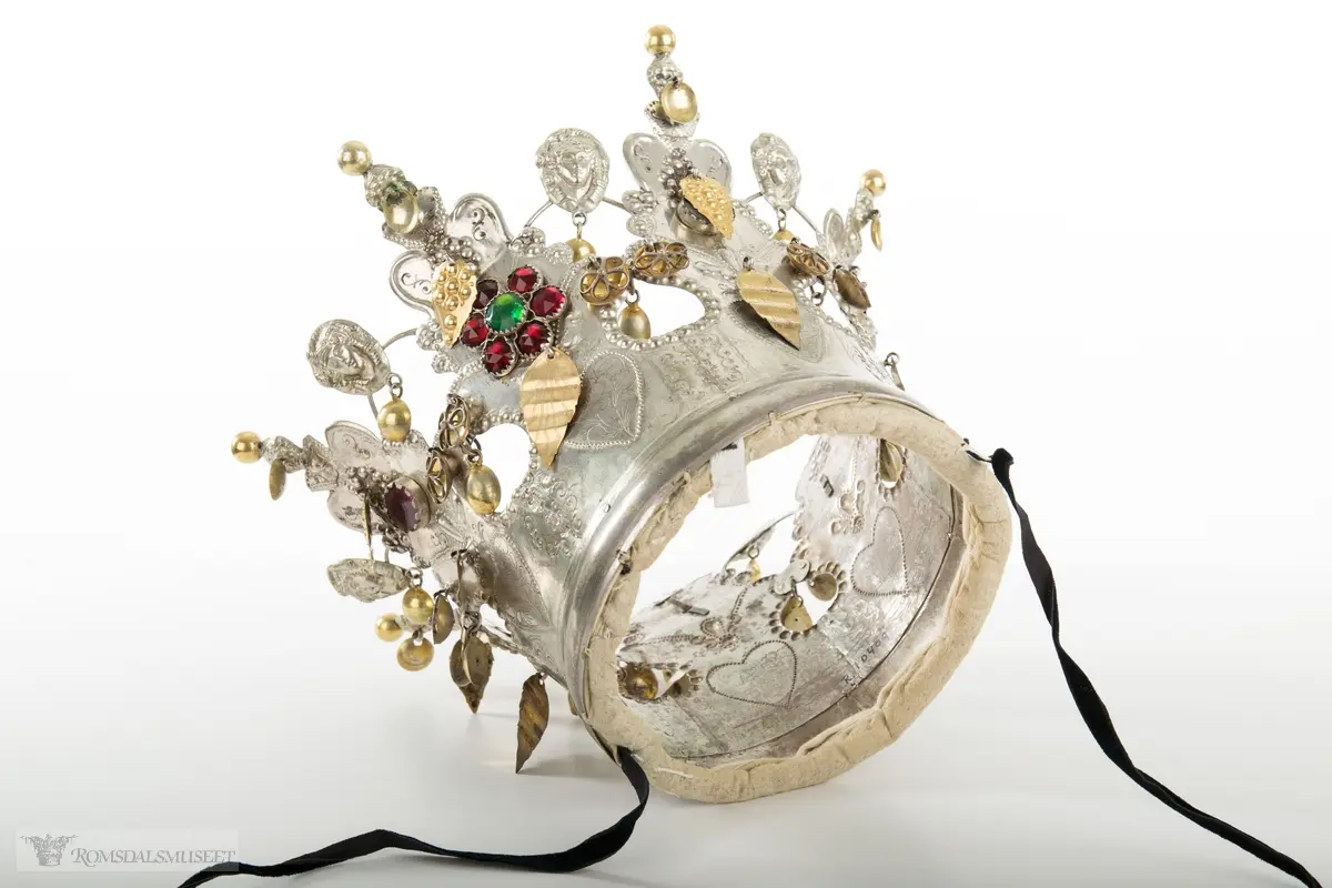 På bøylen mellom delene er loddet på et hode. Hjerte med blomst og blad på hver del.