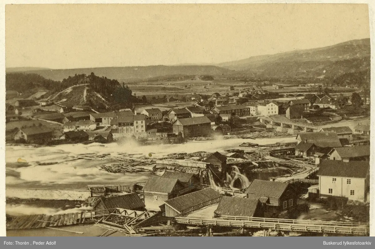Hønefossen
I forgrunnen Øyaområdet med sine arbeiderboliger og verksteder I bakgrunnen Hammerbrugaten og resten av Nordsia. Mye av bebyggelsen brant ned i 1878