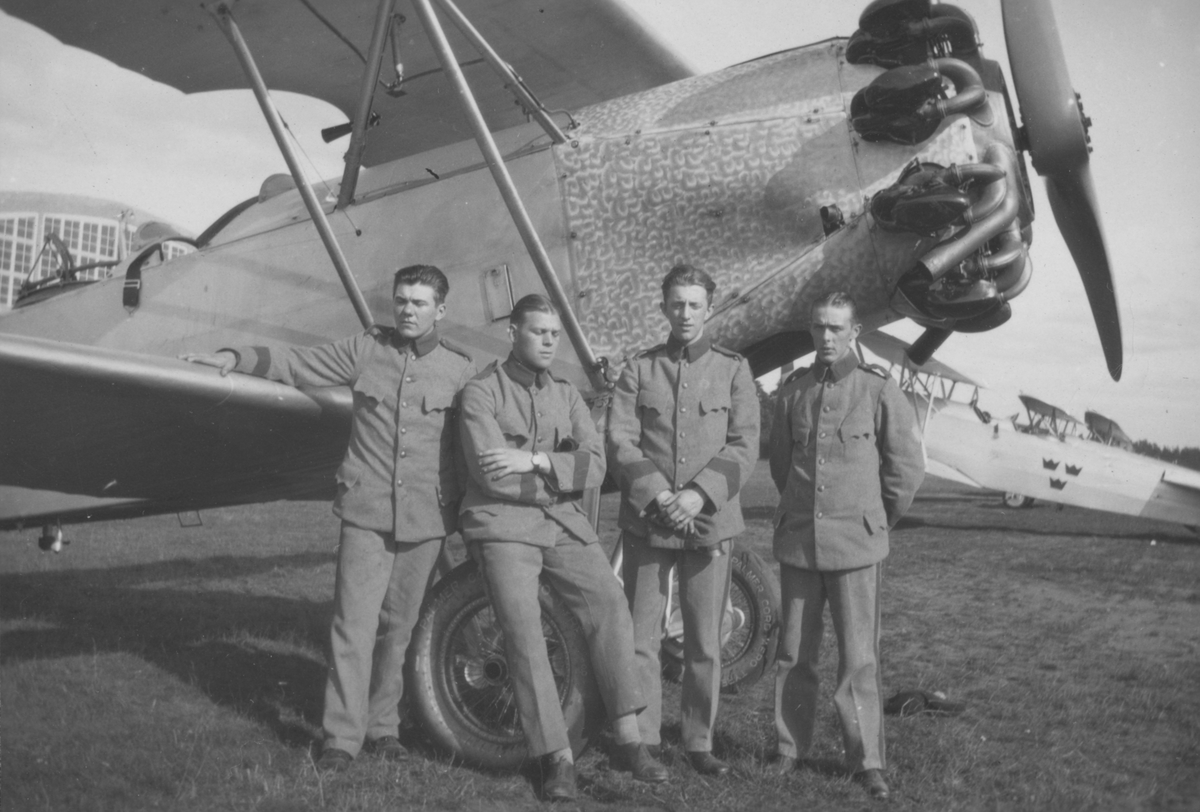 Grupporträtt. Fyra värnpliktiga män vid nosen på flygplan S 6.