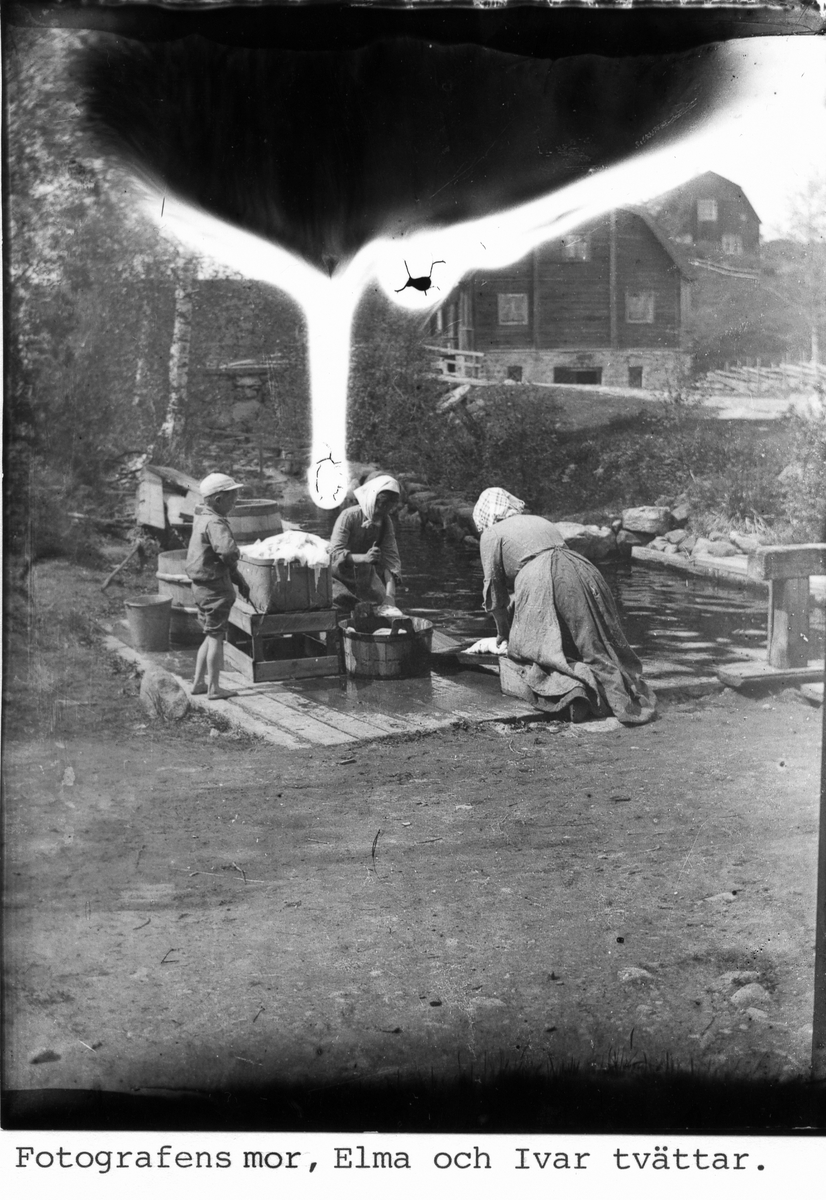 Byk vid Tullkvarn. Fotografens mor Anna Greta, Elma (Elis syster) och Ivar (Elis bror) tvättar.