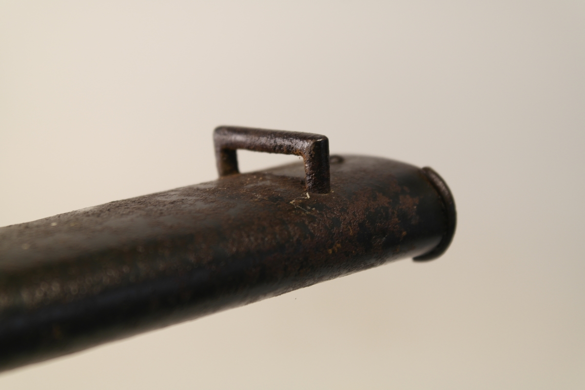 Bajonett (a) med slire (b). 
a) Støpt stål, smidd jern, messing. Stålklinge. Stopper av jern. Messinghåndtak med spor for geværet.
b) Jern.