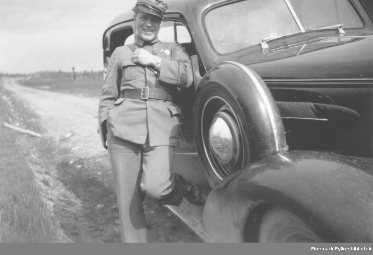 Løytnant og sanitetslege Myhre står lent mot en Chevrolet 1937.