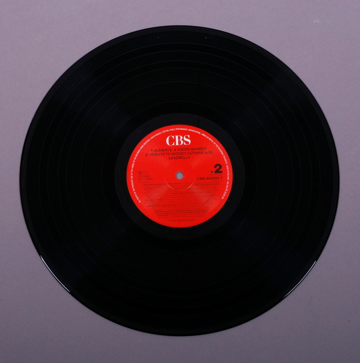 Grammofonplate i svart vinyl og dobbelt plateomslag i papp. Plata ligger i en papirlomme med tekst på.