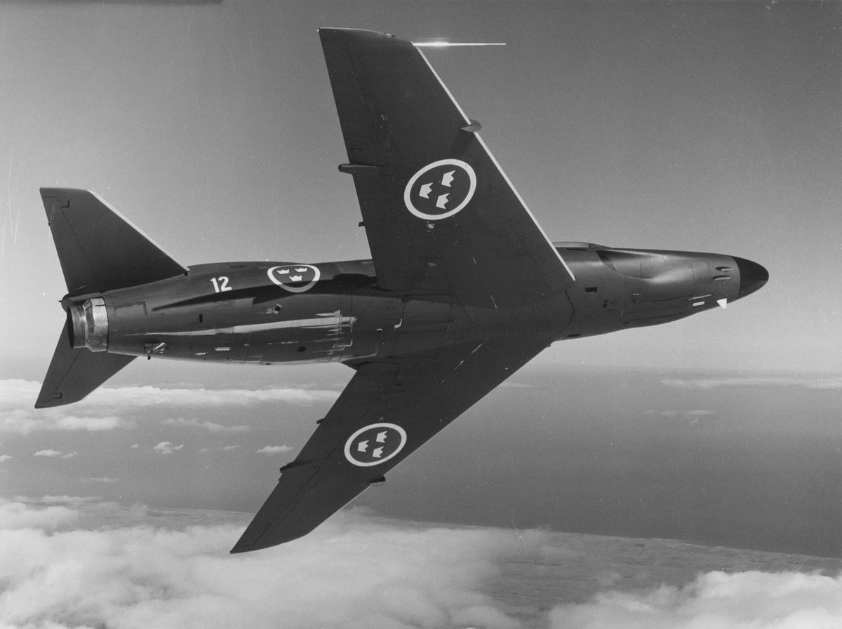 Flygplan J 32B Lansen tillhörande F 12 Kalmar flygflottilj under svängning i luften. Flygplanets buk vänd mot kamera.