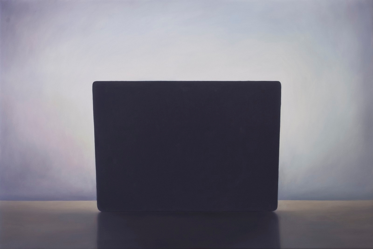 Motivet viser en laptop på et bord som lyser opp veggen bak.