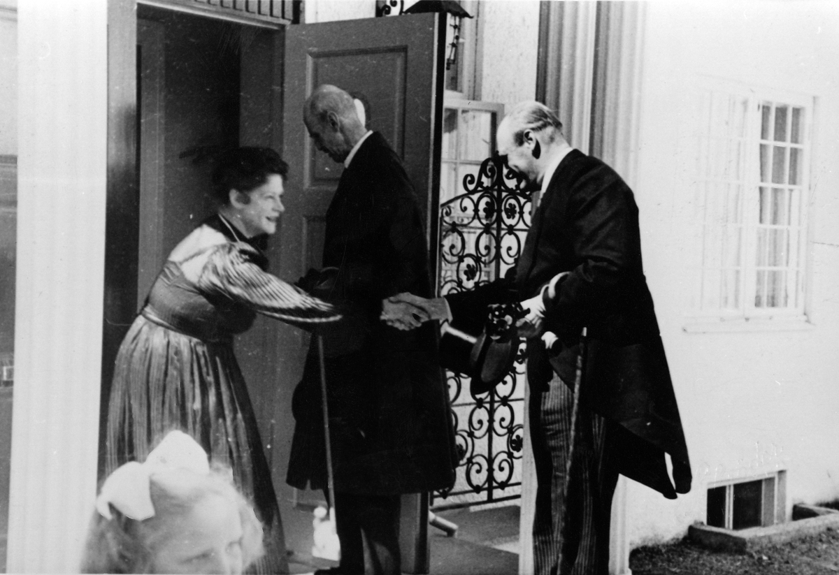 Victoria Bachke mottar kong Haakon VII og kronprins Olav som gjester til Ringve museum. Bildet er tatt på trappen til direktørboligen.