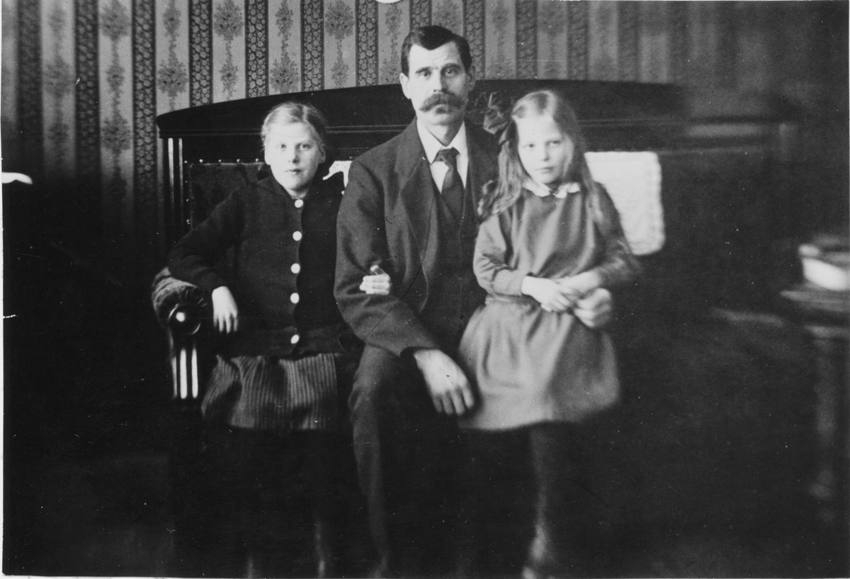 Interiör från uppläggaren August Johannessons lägenhet på Gefle glasbruk.
Från vänster dottern Gertrud född 1908,
August Johannesson 1868-1946 och dottern Svea född 1910.
