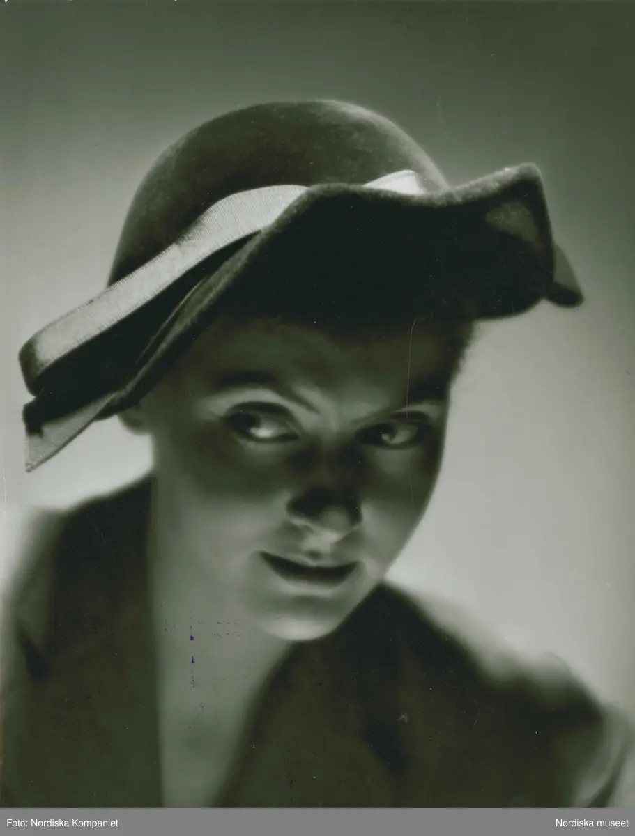 Porträtt av modell i grön velourhatt monterad med rött band. - Nordiska ...