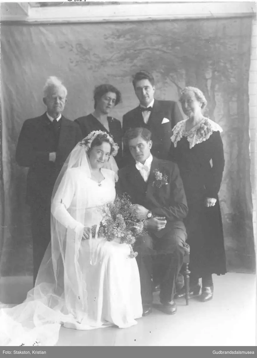 Brudeparet Kolbjørn Grindvold (f. 1919) og Agnes Grindvold (f. Visdal 1922).  
Bak f.v: Erik Rudsar (f. 1867), Ragnhild Berge, Odd Grindvoll (f. 1921), ukjent