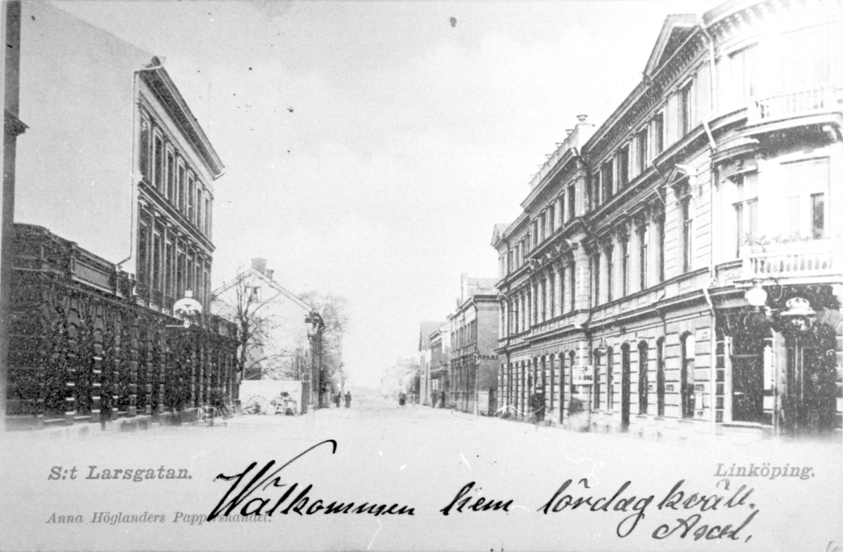 Vykort med motivet S:t Larsgatans bebyggelse taget från Badhusgatan norrrut.
Byggnaden till höger i bild är uppförd i stram nyrenässansstil med kraftig anitkiserande rustik och markerad takgesims. Arkitekt var Johan Ferdinand Janne Lundin (1858-1923) och byggmästare var Oskar Göransson. Byggnaden stod färdig 1884 och 20 oktober öppnade Grand Hotel med hotell- och kaféverksamhet som fanns kvar till slutet av 1960-talet. Även en biljardsalong drevs i byggnaden. 
Övriga verksamheter i huset: 1885, öppnade Hulda Bergs modehandel. Från 1886, Arbetareföreningens läsrum. 1890-1953, Apoteket Kronan. Hotellets restaurang övertogs på 1930-talet av Hushållsskolan Margareta. På 1930- och 40-talet drevs också en dansskola i huset. Även Norén & Englund har funnits i huset i flera decennier fram till år 2000.