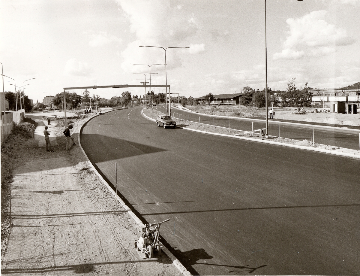 Orig. text: Tanneforsleden, juli 1975.

Gamla Tanneforsvägen sedd norrut, mitt i bild ses korsningen med Nya Tanneforsvägen.