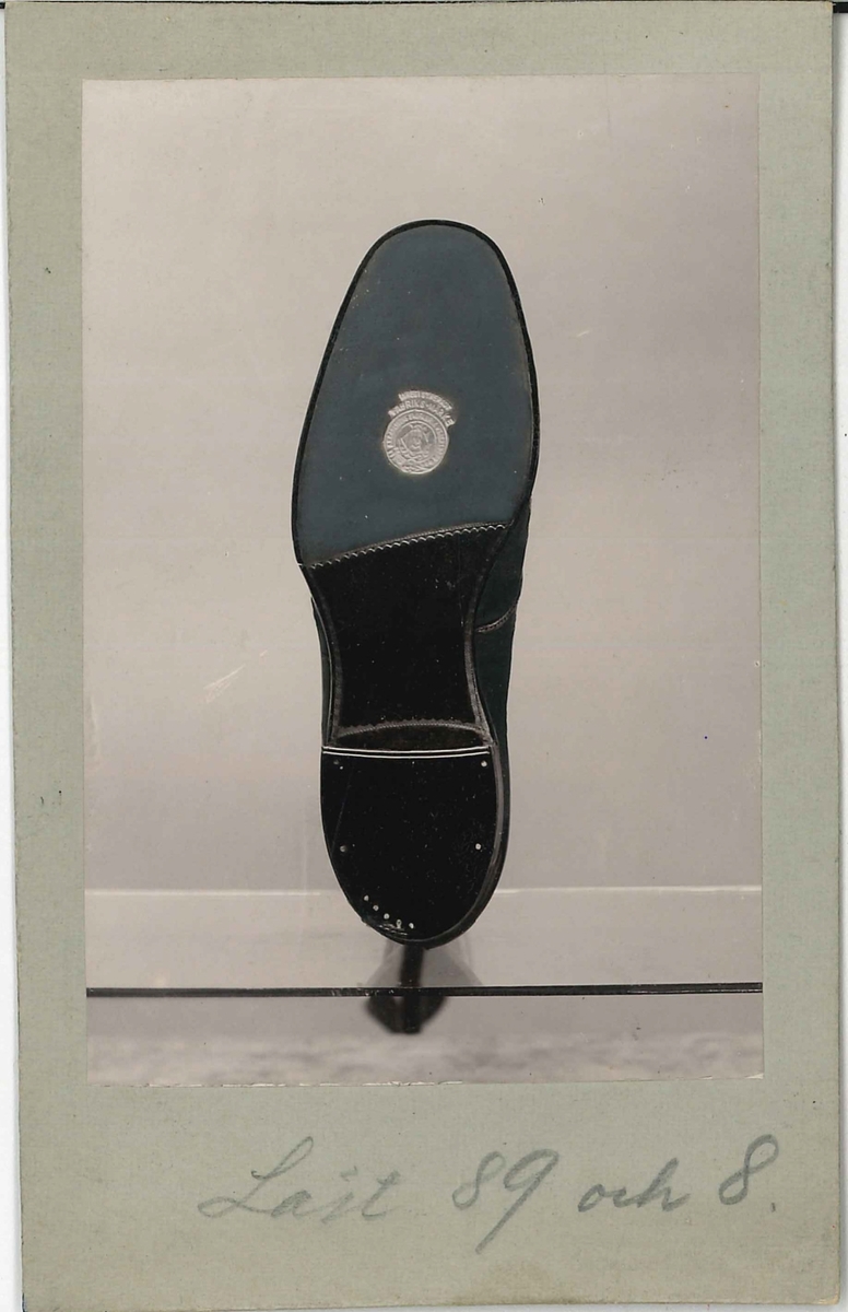 Fotografi av ett skodon. Sko. Bild av undersidan av skon.

Använd som reklam på A F Carlssons skofabrik.

Ingår i en samling med 123 stycken kort i kartong.