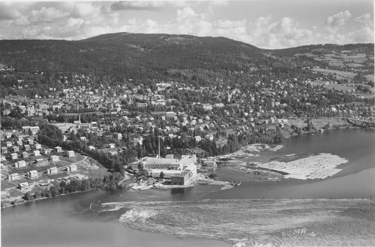 Flyfoto, Lillehammer, oversiktsbilde mot øst, Mesna Kartongfabrikk i forgrunnen, tømmerlense foran t.h. Gudbrandsdal Uldvarefabrik ses t.v.
