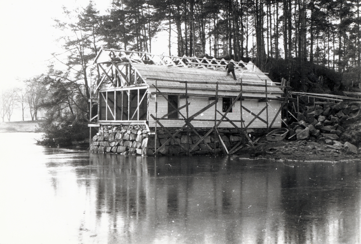 Bildeserie av gjenoppføringa av Larsnesbua, også kallt Seljeset-buda på Sunnmøre Museum, februar 1992. Einar Fagerli er arbeidsleiar for arbeidet, og det er gjennom "Arbeid for trygd"- ordninga ein har fått folk til arbeidet.