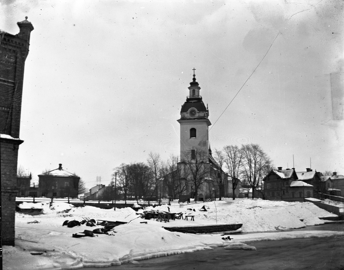 Vy över Heliga Trefaldighetskyrkan och kvarteret Ordinarius till höger. I vänster kant Valskvarn. Foto troligen 1901.