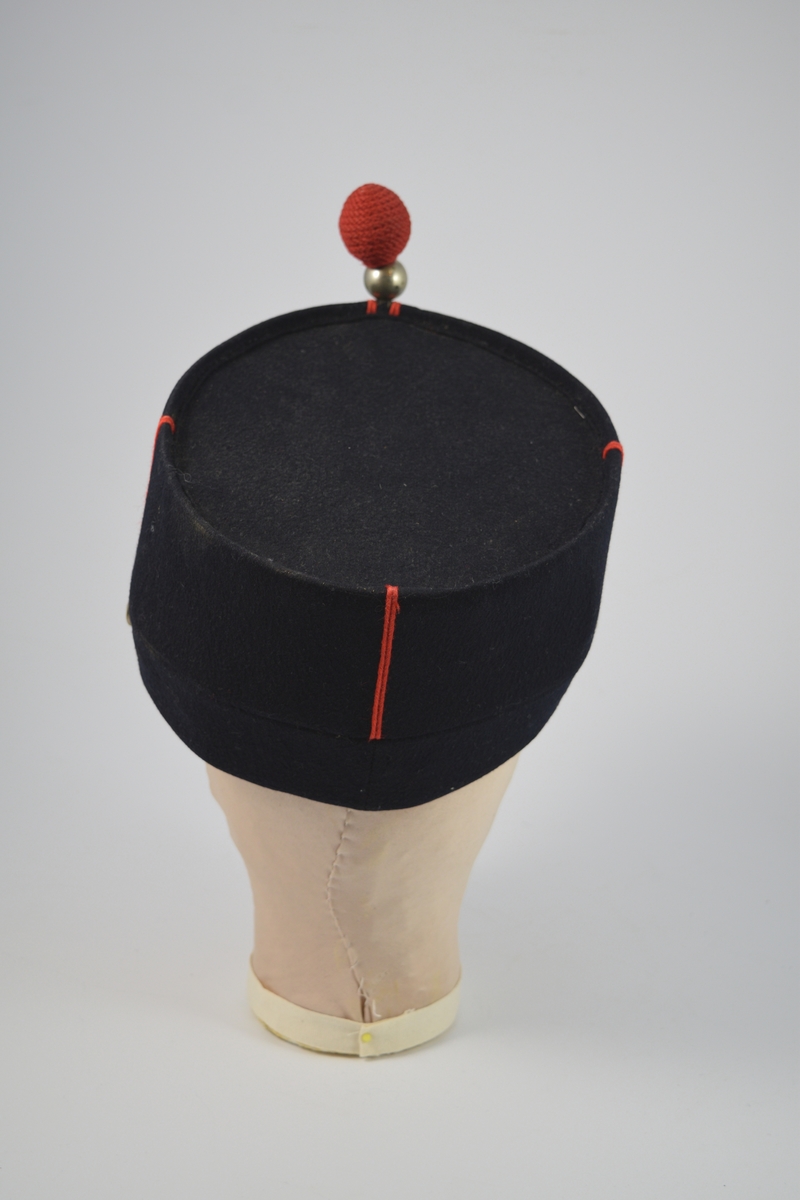 Uniform i to deler, jakke og lue.  a) lett innsvinget m/slag, enkelspent, høy krage; b) bøtteform m/ skygge og distinksjoner