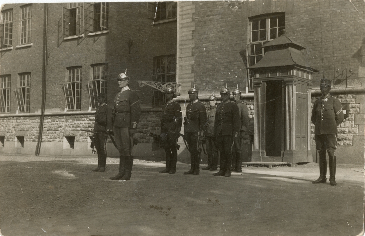 Gruppbild av soldater från Livgardet till häst K 1 uppställda utanför kasernbyggnad.