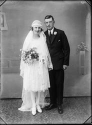 Studioportrett av et brudepar.