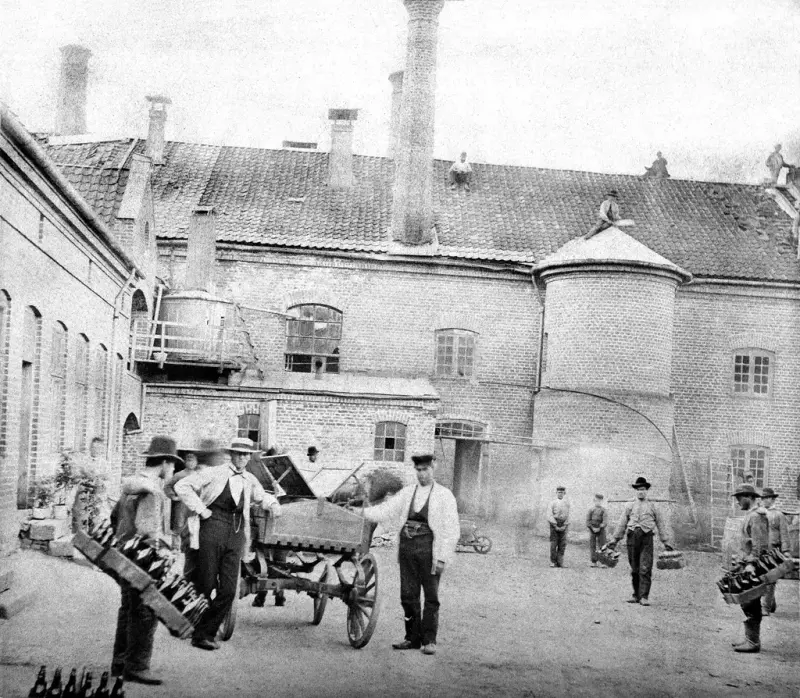 Svart-hvitt foto som viser stor aktivitet i bakgården på Hamar Bryggeri i 1878.