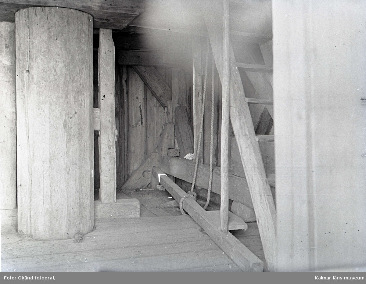 Interiör av en kvarn. Pelaren och trappan finns i bild.