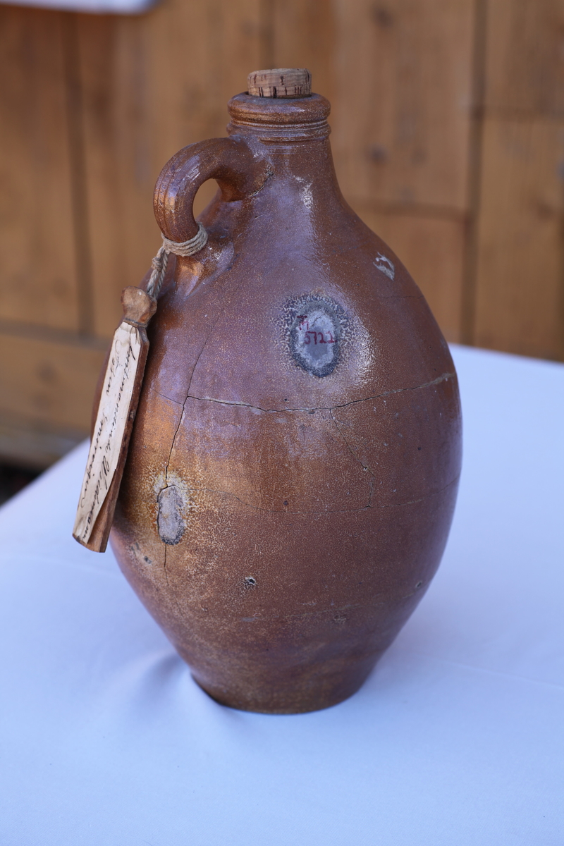 Nyreparert, flere enkeltbiter limt sammen, brun. Hanke øverst oppe, elegant form, kork mangler