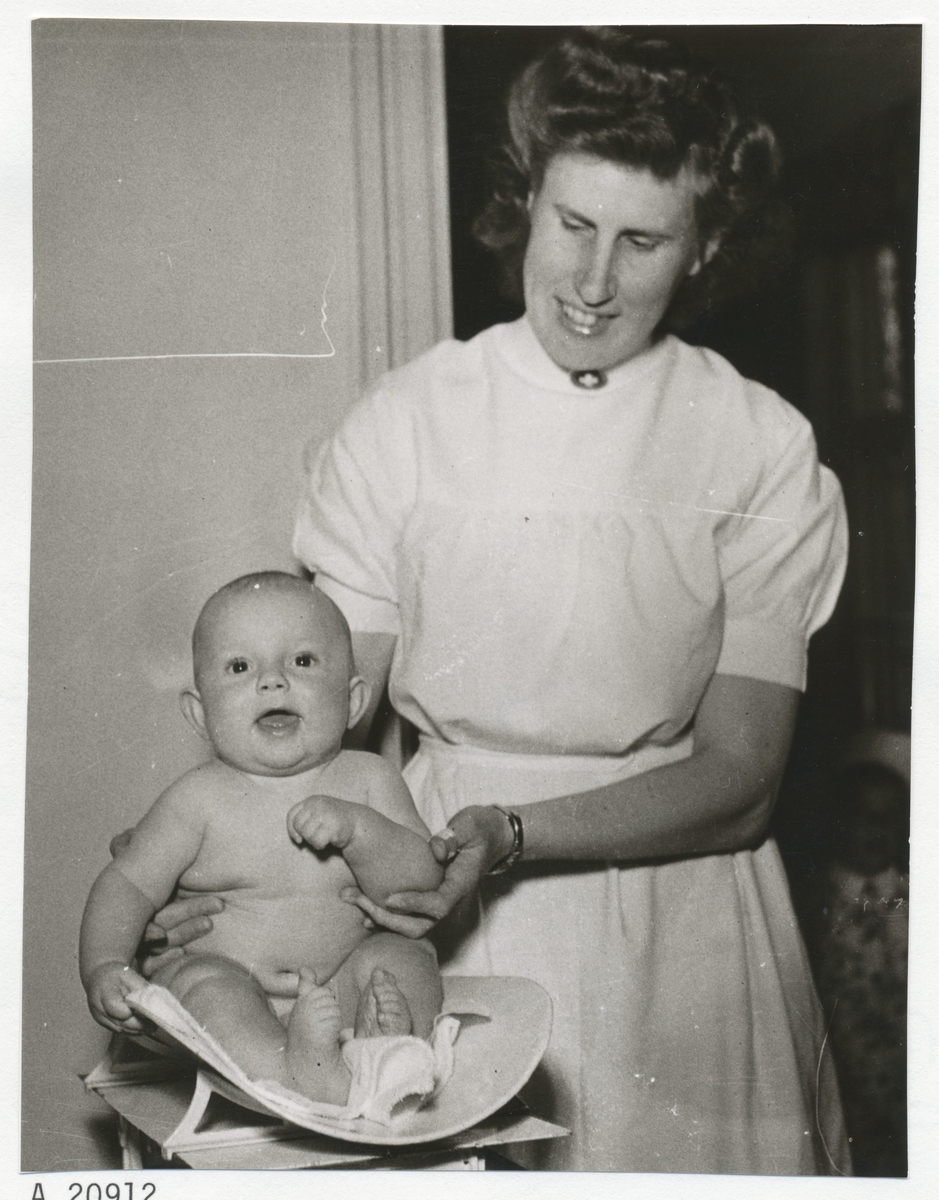 En barnsköterska med ett spädbarn.