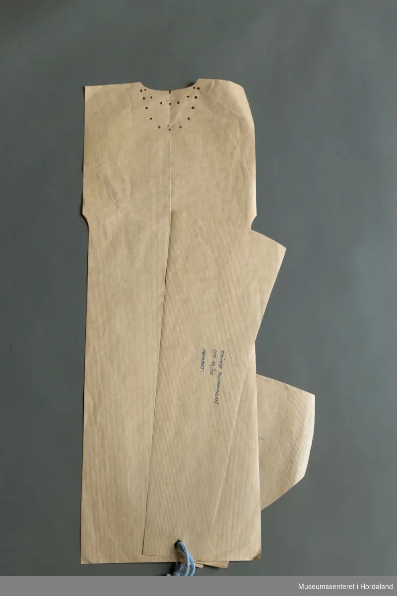 Mønsterskante i papp, brukt til å skjere ut ulike delar av plagg i klesproduksjon. Desse er til einsfarga gensarar i polypropylen, str. 50/52.