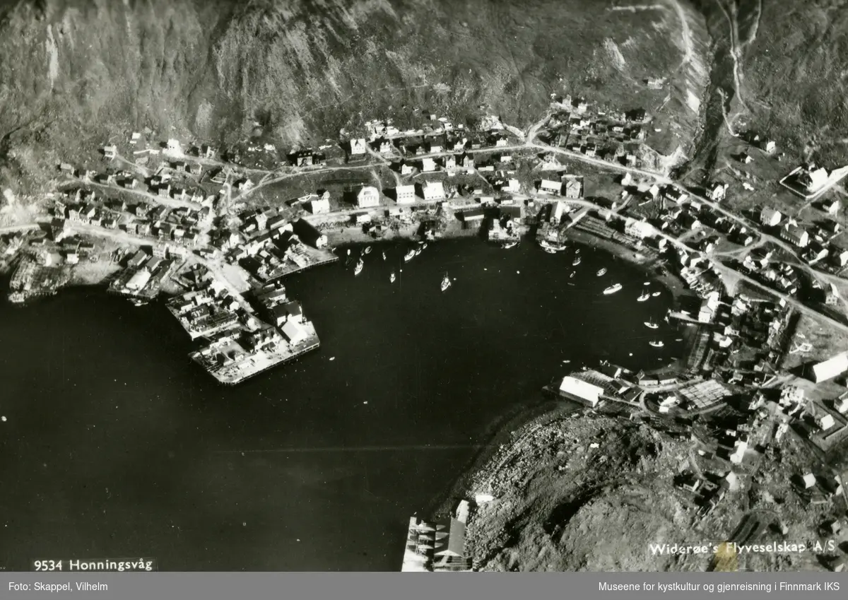 Postkortmotiv. Flyfoto. Honningsvåg med bebyggelsen rundt Indre havn. August 1936.