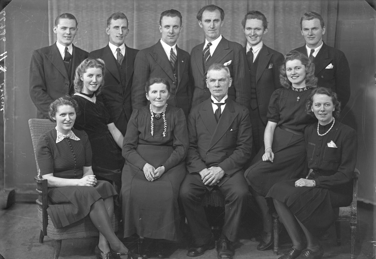 Gruppebilde. Familie. Gruppe på 12, en eldre mann, ei eldre kvinne, seks unge menn og fire unge kvinner.  Bestilt av Claus Dale. Skudenes.