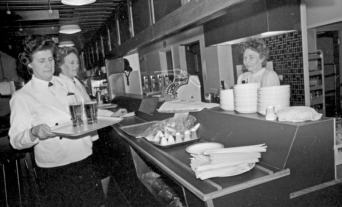Serveringsdamer på "Snorre". 3/4 damer ved serveringsdisken på "Snorre" i første etasje på Saga Hotel. Ølglass på brettet.