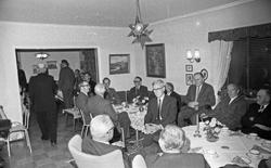 Interiør. Mange voksne menn samlet til selskap i en priavtbo