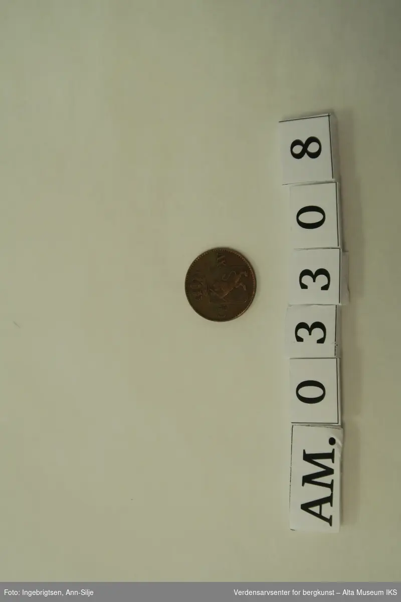 Form: Rund mynt med motiv av Riksvåpen med løve og krone.