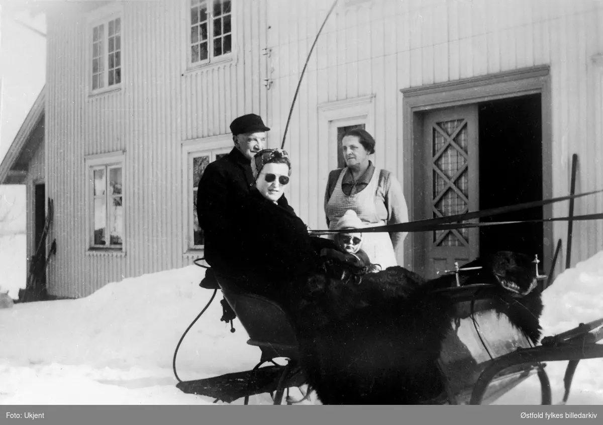 Klar for avreise med hest og slede fra gården Kjos i Skiptvet 1953. Kusk er Hilmar Skipperud, i sleden: Marit og Solveig Hoff, og på trappa Aslaug Skipperud.