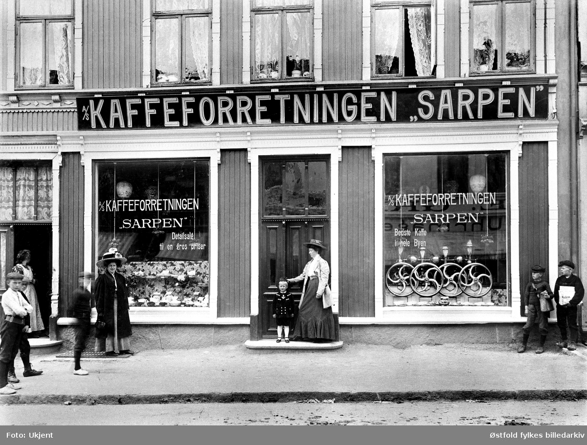 A/S Kaffeforretningen "Sarpen" i St. Marie gate 101, Sarpsborg. Seinere "Kaffemølla" og "Irma" og veskeforretning. Ca. 1905-10. Det var et Kristiania-firma som eide forretningen fram til den i 1918 ble overtatt av Carl Sørensen., den het senere Kaffemølla og ble drevet av Sørensen i mange år. 
Vindusreklame: Bedste Kaffe i hele Byen.