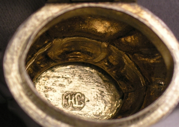 Enl liggare:
Svampdosa af silfver i form af en flaska med gängkant lock försett med en förgylld krona. På framsidan ingr. Â¨G O D.Â¨
